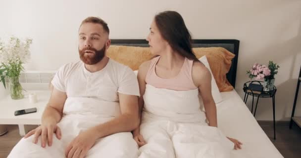 Cute couple overslept, panicking and screaming with big eyes . Funny man and woman waking up, realizing that they are late and quickly getting out of bed .Concept of lifestyle. — Stock Video