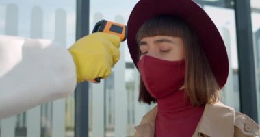 Genç bayan yolcunun Covid-19 semptomlarını taramasını yakından izleyin. Sınır kapısındaki gezginlerin sıcaklık kontrol noktaları. Koronavirüs ve pandemik kavramı.