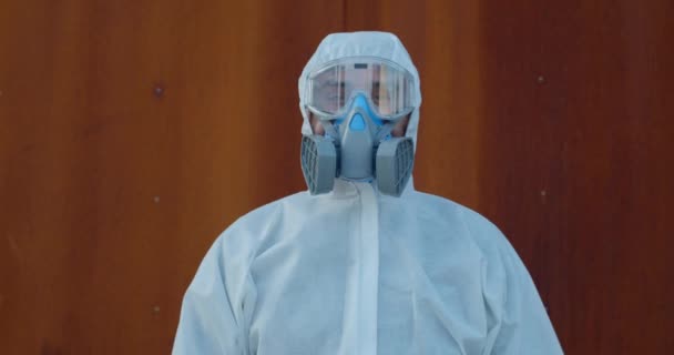Portret pracownika medycznego w kombinezonie ochronnym i masce patrzącej w kamerę. Koncepcja Covid -19, pandemia i ochrona przed wirusami. Powiększ. — Wideo stockowe