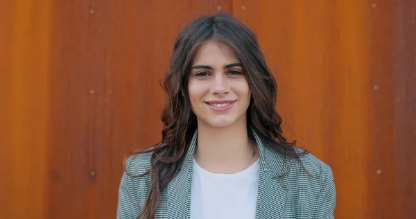 Vista de cerca de chica bastante feliz sonriendo y mirando a la cámara. Joyfull millennial mujer en ropa casual posando a la cámara. Concepto de emociones positivas. Fondo naranja . —  Fotos de Stock