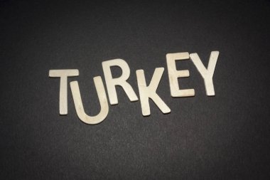 Siyah bir arka plan üzerinde ahşap harflerle yazılmış Türkiye