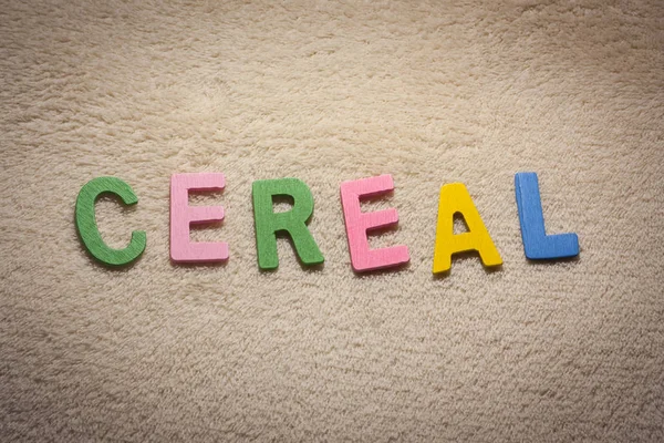 Cereal written with colorful wooden letters on light background