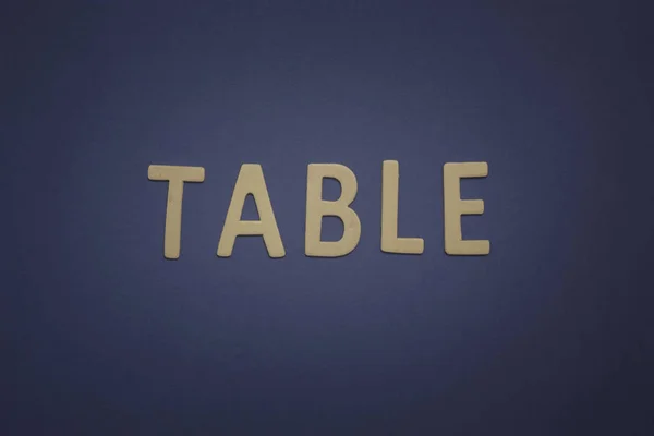 テーブルを意味する青い背景に木製の文字で書かれた、 — ストック写真