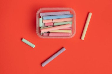 Kırmızı arkaplanda tebeşir renkleri izole bir kavram anlamına gelir