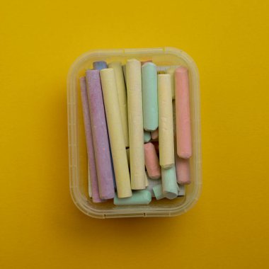 Sarı arkaplanda izole edilmiş renkli kalemler bir kavram anlamına gelir