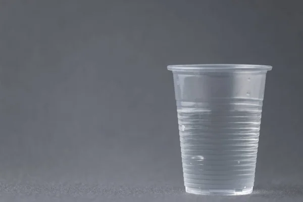 Plastové Pitné Sklo Naplněné Vodou Izolované Šedém Pozadí Znamená Koncept — Stock fotografie