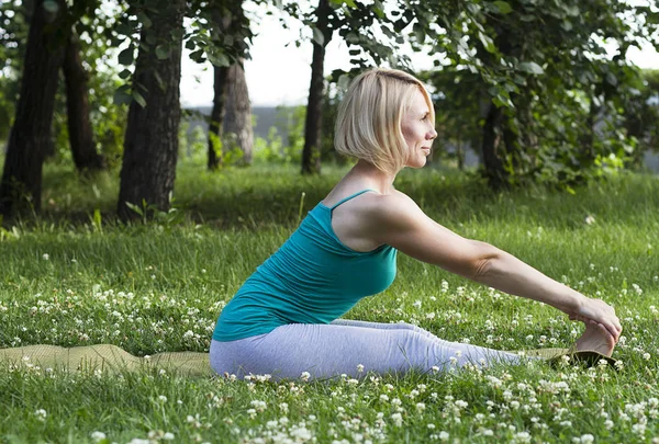 Joven rubia haciendo yoga y gimnasia en el parque — Foto de Stock