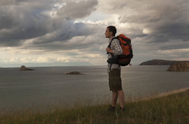 Genç turizm adam göl, Deniz Baykal, yaz turist üzerinde bir sırt çantası ile yürümek, özgürlük ve mutluluk, güzel yaban hayatı