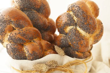 Uzun somun, beyaz buğday ekmeği. Haşhaş tohumlu pembe ekmek. Beyaz arkaplanda tatlı.