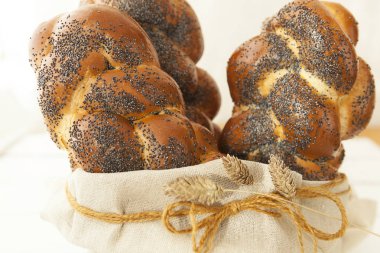 Uzun somun, beyaz buğday ekmeği. Haşhaş tohumlu pembe ekmek. Beyaz arkaplanda tatlı.