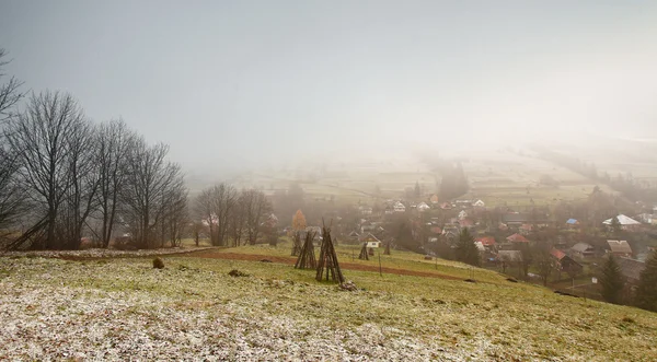 Late herfst mistige ochtend in een dorp. Eerste sneeuw — Stockfoto