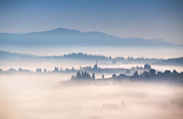 Herbst neblig Morgen in den Bergen. Alpendorf auf den Hügeln — Stockfoto