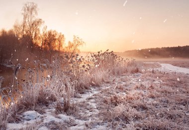 Kış misty dawn Nehri üzerinde. Kar taneleri, kar yağışı. Güneşli wint
