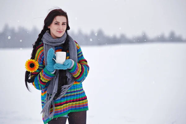 Mooie jonge vrouw in een trui op een winter lopen met een cup-o Stockafbeelding
