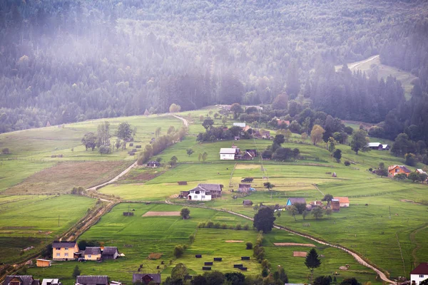 Alpské vesnice v horách. Kouř a opar nad kopci — Stock fotografie