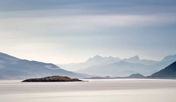 Costa de Noruega mar en las nubes de neblina. Baliza en una roca —  Fotos de Stock