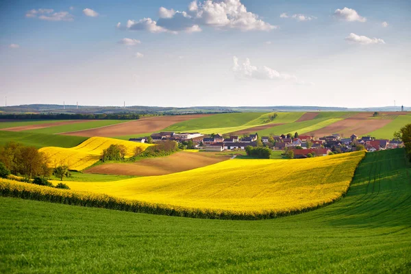 Austria campos de colza de primavera. Pueblo en una colina . — Foto de Stock