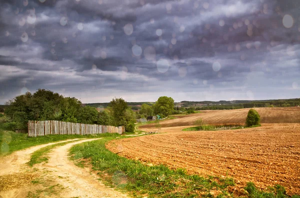 Rain. Spring storm clouds above country road — Stock Photo, Image