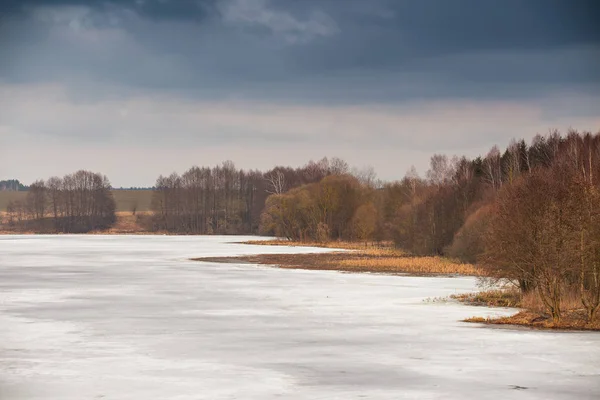 No início da primavera. Temporada da lama. Lago sob gelo e neve derretendo . — Fotografia de Stock