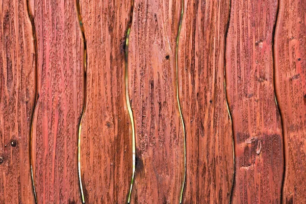 Wooden curved fence of brown color.