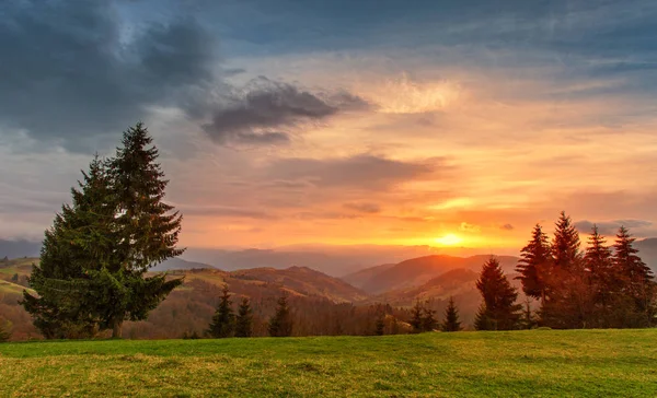 Jarní barevné západ slunce. Zelené kopce. Jarní krajina — Stock fotografie