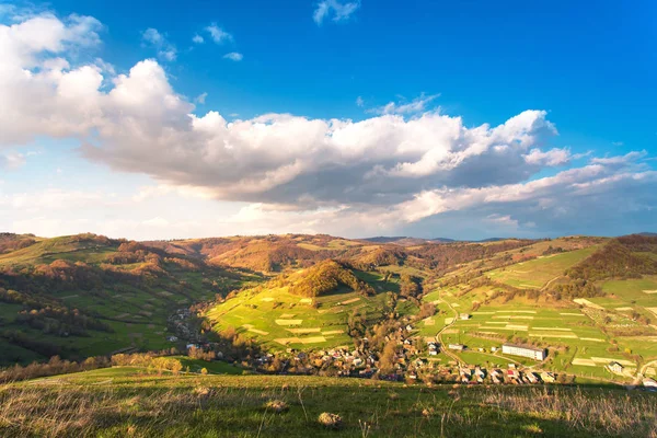 Soleado día de primavera. Pueblo en verde valle de montaña — Foto de Stock