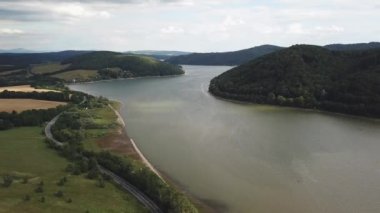 Göl ve dağlarla dolu yaz manzarası. Göl kenarındaki yol. Deponun hava görüntüsü Velka Domasa, Ondava nehri, Slovakya