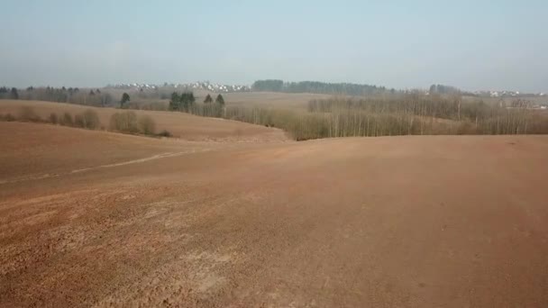 早春の空の耕起フィールドのパノラマ 園芸シーズンの始まり 空中ビュー 日当たりの良い3月の田園風景 ベラルーシ ミンスク地域 — ストック動画
