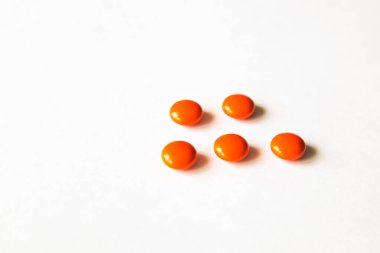 Hapları ve tabletleri beyaz arka plana koyun. Günlük vitaminler, iyi bir sağlık ve sabah rutini için. Eczane temalı. Çok renkli haplar ve kapsüller yakın plan.