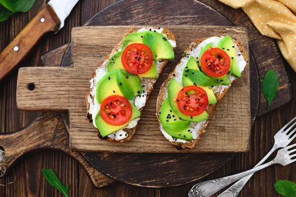 Bright vegan avocado sandwiches on a wooden cutting board Stock Picture