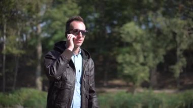 Genç adam telefonla güneş gözlüğü talkning