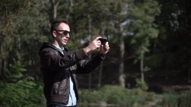 Mutlu bir çekici genç adam güneş gözlüğü kullanın video sohbet