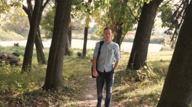 Genç çekici adam parkta yürüyüş mutlu