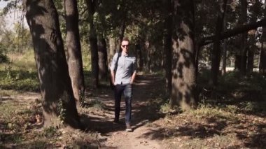 Genç çekici adam parkta yürüyüş mutlu