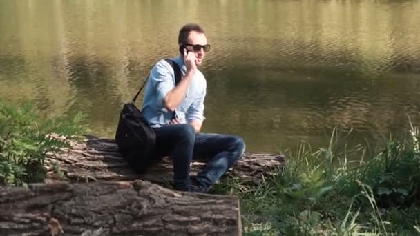 Jovem atraente feliz IT homem falando por telefone — Vídeo de Stock