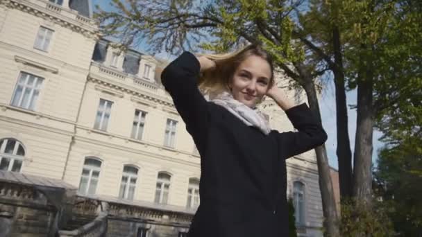 Giovane ragazza attraente posa in macchina fotografica e giocare con i capelli — Video Stock