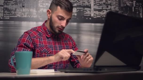 Jeune homme effectuant un paiement en ligne avec carte de crédit — Video