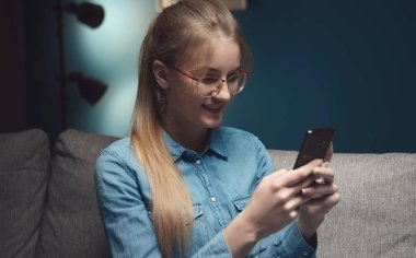 Karanlıkta akıllı telefondan mesaj atan kadın