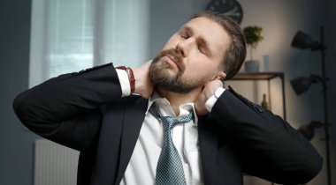 Yorgun ofis çalışanı boyun masajı yapıyor.