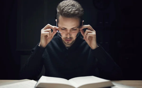 Homem lendo livro na escuridão — Fotografia de Stock