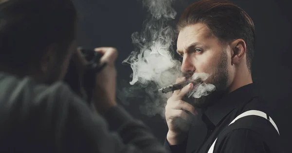 Fotoğrafçı sigara içen adamı çekiyor. — Stok fotoğraf