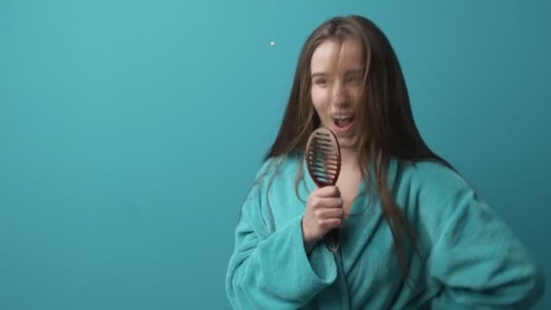 Överlycklig dam dansar i badrock och sjunger i pensel — Stockvideo