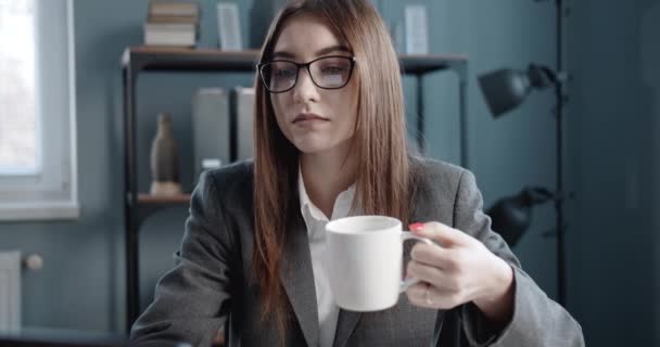 Empresaria bebiendo café y trabajando en el portátil — Vídeo de stock
