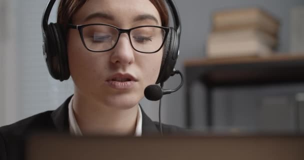 Jonge vrouw in headset ondersteunende klant tijdens telefoongesprek — Stockvideo