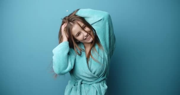 Mooi meisje met lang haar in badjas met plezier in de studio — Stockvideo