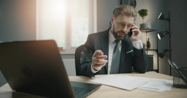 Obchodník mluví po telefonu v kanceláři — Stock video