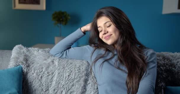 Щаслива жінка з темним волоссям розслабляється вдома — стокове відео