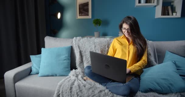 Güzel bayan evde dinleniyor ve dizüstü bilgisayar kullanıyor. — Stok video