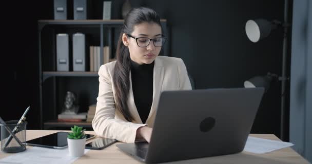 Portré komoly lány használó laptop a modern irodában — Stock videók