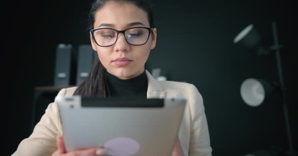 Mulher concentrada trabalhando em dispositivo eletrônico — Vídeo de Stock